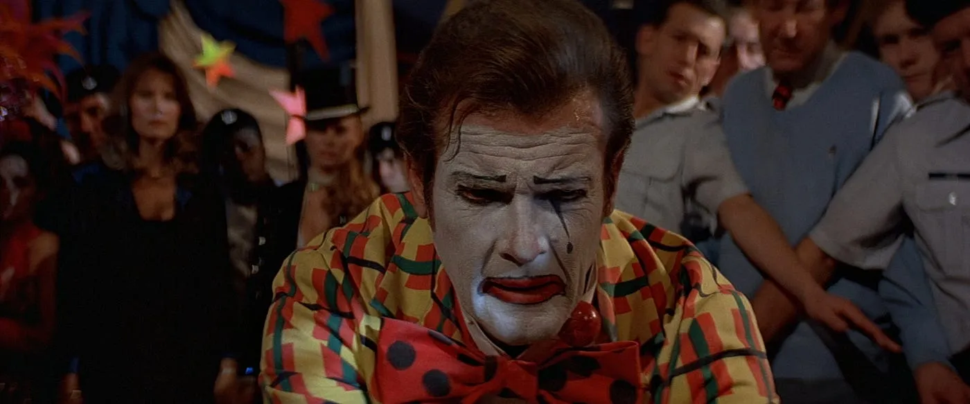 Roger Moore in full sad-clown makeup and a garish costume, attempting to save the world at a circus in Octopussy