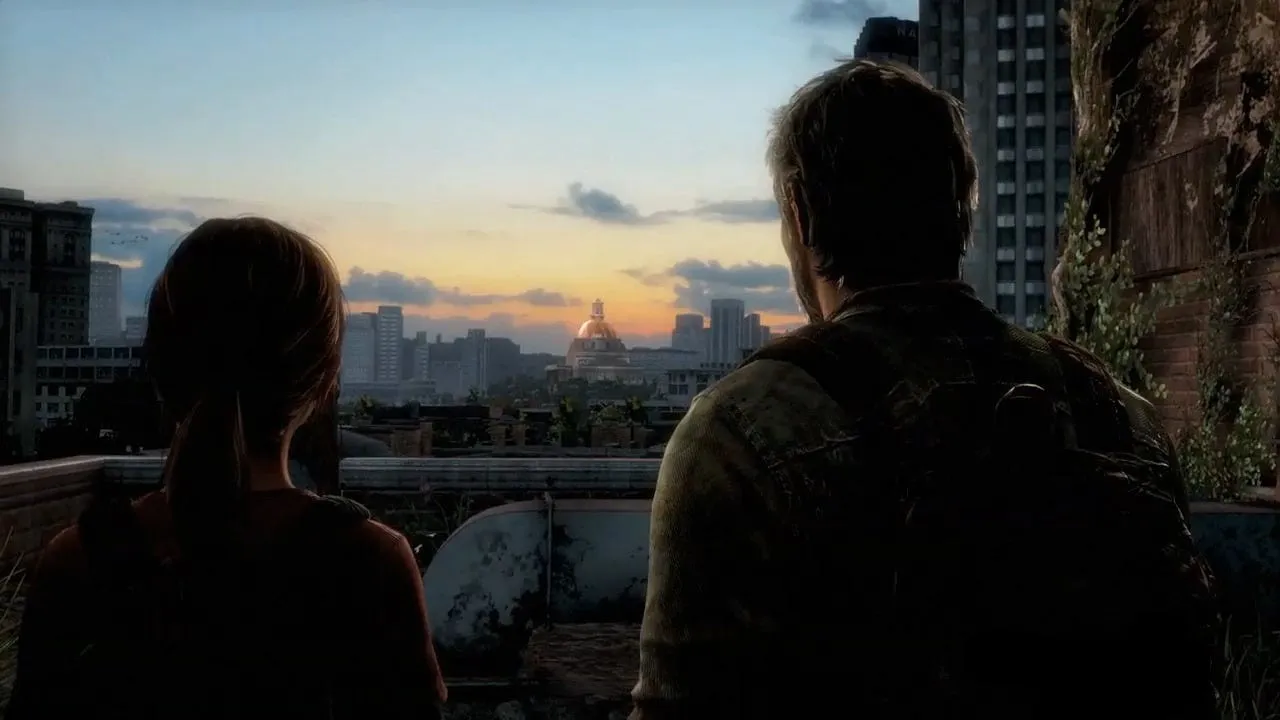 Ellie and Joel seen from behind, silhouetted against a sunset over a ruined city skyline with a domed building in the distance